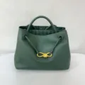 Dark green calfskin handbag detail, featuring gold-toned metal knot and braided strap design. - Dark Green
