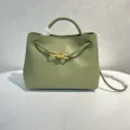 Olivgrüne Lederhandtasche mit stilvoller goldener Knoten-Hardware und geflochtenen Riemendetails. - Travertingrün