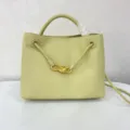 Light green leather bucket bag with braided handle and gold knot hardware detail for daily use. - Milk Yellow