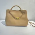 Detailed view of the beige leather handbag featuring elegant braided straps and gold bow hardware. - Milk Tea