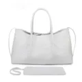 Detailed view of the white woven leather tote bag showcasing intricate texture and matching pouch. - White