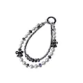 Close-up detail of double-strand beaded phone charm with grey pearls and black bows. - Black Double Chain