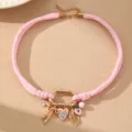 Rosa geflochtene Choker-Halskette mit süßen Anhängern und goldenem Verschluss. - Rosa