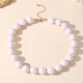 Elegante collana statement con perle acriliche bianche e chiusura dorata da donna. - Bianco