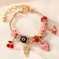 Nahaufnahme des goldenen Bettelarmbands mit roten Perlen, Kirschen und Liebesanhänger. - Rot Weiß Gitter Kirschstil (BZ2406hongseHB)