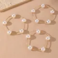 Primer plano de delicadas pulseras de alambre dorado con elegantes perlas falsas. - Estilo 8