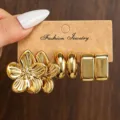 Goldenes Metall Ohrring Set mit Blumen Creolen und geometrischen Block Designs auf Karte. - Gold Sakura Quadrat Set