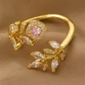 Exquisiter vergoldeter offener Ring mit glitzernden Zirkoniasteinen und rosa Hauptstein. - Rosa Edelstein Blumen- und Blattstil (RZ0910fenzuan)