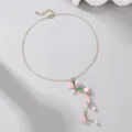Delicate gold-tone Y necklace featuring pink lily of the valley flowers, pearls, and green leaves. - Pink Style (NZ2970)