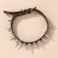 Vista dettagliata di un collare in pelle marrone con borchie appuntite e anelli metallici. - Caffè