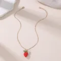 Goldfarbene Halskette mit rotem Erdbeer-Anhänger, grünem Blatt sowie dekorativem Blumen-Charm. - Roter Erdbeer-Stil
