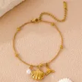 Nahaufnahme von goldener Muschel und Wal-Anhänger an einem eleganten Boho Perlenarmband. - Einzeln Fischschwanz / Gold