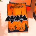 Detailed view of funny Halloween bat earrings with a festive orange display card. - Black Boo Bat (2890-4)