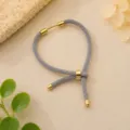 Grijs geweven Milan-koordarmband met gouden metalen schuifregelaar voor DIY-sieraden maken. - Grijs