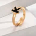 Nahaufnahme des stilvollen vergoldeten offenen Rings mit schickem schwarzem Buchstaben K. - Buchstabe K / Gold
