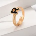 Detailansicht des modischen goldenen verstellbaren offenen Rings mit schwarzem Emailleschmuck. - Buchstabe R / Gold