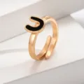 Nahaufnahme des verstellbaren goldenen Buchstaben-U-Rings mit schicker schwarzer Emaillierung. - Buchstabe U / Gold
