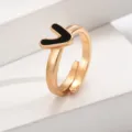 Nahaufnahme eines schicken verstellbaren vergoldeten Buchstaben-V-Rings mit schwarzem Emaile-Inlay. - Buchstabe V / Gold