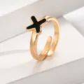 Nahaufnahme Detail eines stilvollen goldenen offenen Rings mit einem schwarzen Kreuzmotiv. - Buchstabe X / Gold