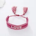 Pink woven bracelet with tassel and LOVE letter detail, stylish couple jewelry accessory. - Pink