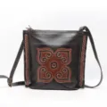 Borsa a tracolla in vera pelle marrone scuro con motivo floreale impresso etnico e finitura intrecciata. - Caffè Scuro