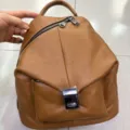 Zaino da donna in vera pelle marrone con tasca frontale e robusti dettagli metallici. - Marrone