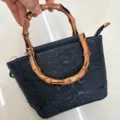 Borsa a mano in pelle goffrata nera con manico in bambù, variante borsa retrò vintage. - Nero