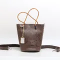 Stylish genuine leather bucket bag with embossed floral design, top handle and shoulder strap. - Coffee
