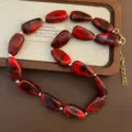 Rot und schwarz marmorierte Perlenkette mit goldener Verlängerungskette, stilvoller Modeschmuck. - Dunkelrot
