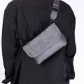 Closeup of grey men chest bag with adjustable strap and metal hardware for daily trend style. - Frosted Gray