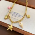 Detailed view of the ocean style titanium steel necklace with cute shell and starfish charms. - Conch Necklace (03-E23) / Gold