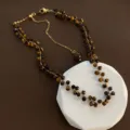 Detailansicht der Tigerauge Perlenkette mit facettierten Edelsteinperlen und goldener Kette. - Facettierte Tigerauge Goldene Kettenhalskette (04-J27)
