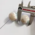 Close-up detail of natural green shell mother of pearl bead measured by tool for DIY craft. - Approx 21mm Single Bead