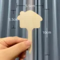House-shaped wooden plant label with 10cm height measurement as shown held in hand - Wooden Small House