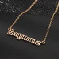 Nahaufnahme der goldenen Schütze Buchstabe Halskette Anhänger mit feiner Kette auf dunklem Grund. - Schütze