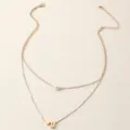 Goldfarbene mehrlagige Kette mit Perlenanhänger und Buchstabenherz-Charm, Schmuck-Detailaufnahme. - Buchstabe U Stil (NZ2456-U) / Gold