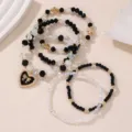 Detailansicht des charmanten Perlenarmband-Sets mit schwarz-weißen Perlen und Herz-Schleife. - Schwarz und Weiß (Klee)