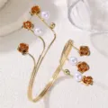Bracciale rigido da braccio floreale in metallo dorato con perle, gioiello trendy chic. - Bracciale con Perle Artificiali e Fiore di Rosa