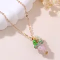 Detailed close-up of a charming gold chain necklace with colorful resin grape pendant and flower. - Pink Grape