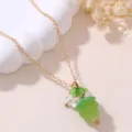 Close-up detail of the green resin grape pendant necklace with a delicate gold chain and leaf charm. - Green Grape