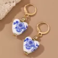Close-up detail of vintage blue and white porcelain heart earrings with gold leverback closure. - Blue Floral Heart-Leverback (EZ5256lanse-1)