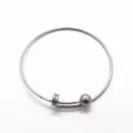 Detalle en primer plano de pulsera ajustable de acero inoxidable con cuenta deslizante minimalista. - Color acero