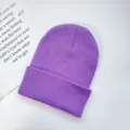 Close up of a cozy purple knit beanie hat, showing soft wool texture and rolled cuff detail. - One Size / Purple