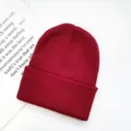 Close-up detail of burgundy knitted beanie ribbed texture autumn winter warm hat display - One Size / Burgundy