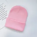 Close-up detail of plain pink knit beanie hat, soft knitted fabric, minimalist cold hat style. - One Size / Pink