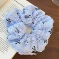 Coletero de encaje azul claro con patrón de lazo negro sobre fondo de libro detalle. - Estilo 21 Fruncido Encaje Lazo