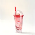 Close-up of pink Christmas double walled straw cup with a miniature Santa inside - 650ml / Santa Claus