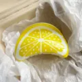 Close-up of a vibrant yellow lemon-shaped resin hair claw clip inside a package box - 9cm / Lemon Print