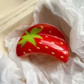 Close-up of a sweet glossy red strawberry pattern acetate hair claw clip in paper - 9cm / Strawberry Print