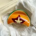 Macro detail of papaya pattern fruit hair claw clip with glossy finish on tissue paper - 9cm / Starfruit Print